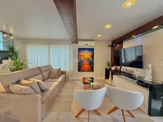 Sala de estar moderna com sofá e televisão em um imóvel no Brasil.