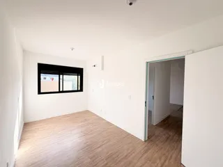 Sala de estar com piso de madeira clara e paredes brancas.