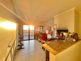 Ambiente interno de uma sala de estar com portas de vidro abrindo para o exterior.