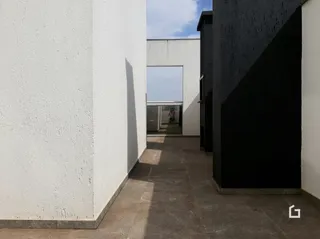 Vista de um corredor externo entre duas paredes de cores contrastantes.