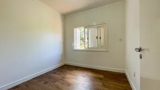 A sala apresenta paredes brancas e piso de madeira.