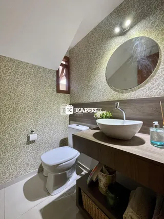 Banheiro com revestimento de papel de parede e bancada de madeira.