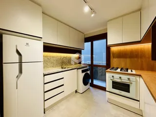 Cozinha moderna com armários brancos e bancada clara.