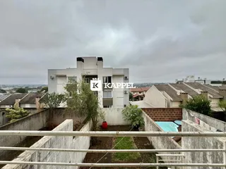 Fachada de um prédio residencial moderno em Lajeado, com uma piscina visível no primeiro plano.