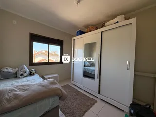 Quarto com cama e armário branco em um apartamento.
