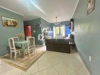 Sala de estar com mesa de jantar e sofá em um imóvel no Brasil.