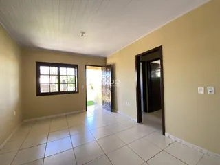 Corredor com paredes claras e piso de cerâmica em uma residência.