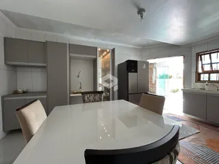 Foto de uma cozinha moderna com armários cinzas e mesa grande.