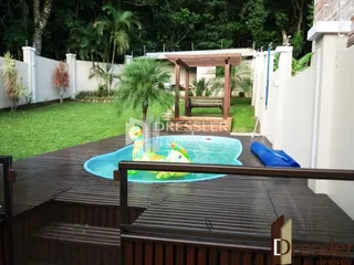 Vista de uma piscina e deck de madeira em uma propriedade no Brasil.