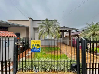 Fachada de uma residência em Lajeado, Brasil, com cerca e jardim na frente.