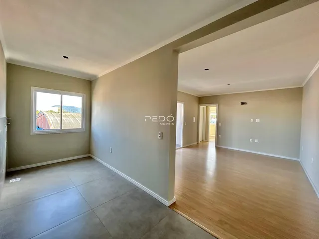 Ambiente interno de uma sala com piso de cerâmica e passagem para outra área.