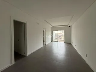 Hall de entrada de uma residência com paredes brancas e piso claro.