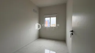 Corredor interno com paredes brancas e piso claro.