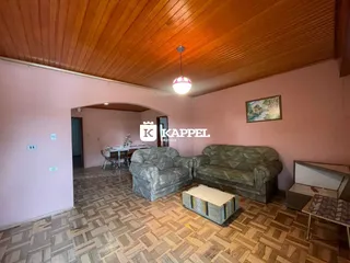 Sala de estar com sofá e piso de madeira em um imóvel em Lajeado.