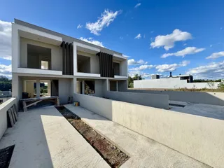 Fachada de uma casa moderna de dois andares em Lajeado, Brasil, com muro de contenção.