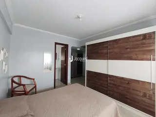 Quarto com armário grande e cadeira de madeira.