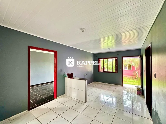 Sala de estar com piso de cerâmica clara e uma bancada branca em um imóvel em Lajeado.
