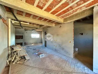 Foto de uma área interna em construção com teto de tijolos exposto.