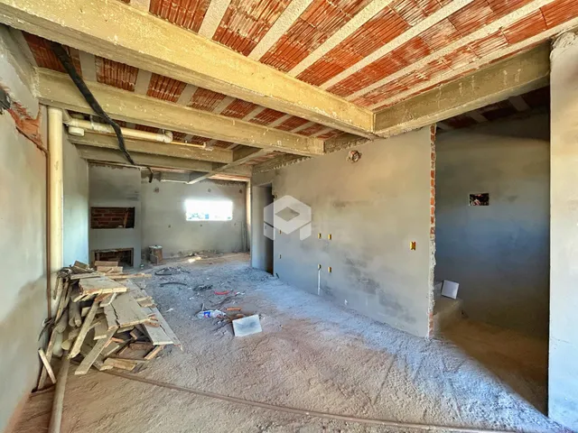Foto de uma área interna em construção com teto de tijolos exposto.