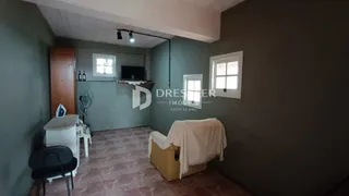 Ambiente interno de uma sala com piso de cerâmica e paredes em tom de verde.