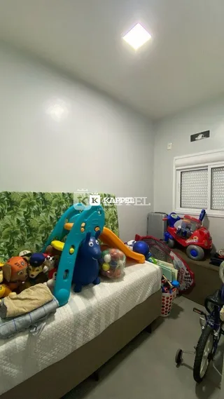 Quarto com cama e brinquedos espalhados no ambiente.