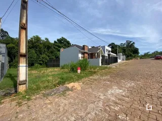 Vista externa de uma propriedade com vegetação e estrada de terra.