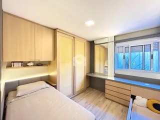 Quarto com armários em madeira e janela no imóvel.
