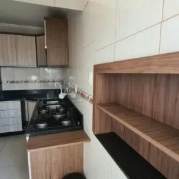 Foto de uma cozinha com armários de madeira e bancada escura.