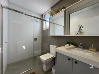 Foto de um banheiro moderno com box de vidro e louças sanitárias.