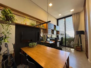 Ambiente interno de um escritório com mesa de madeira e grandes janelas.