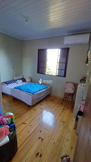 Quarto com piso de madeira e janela.