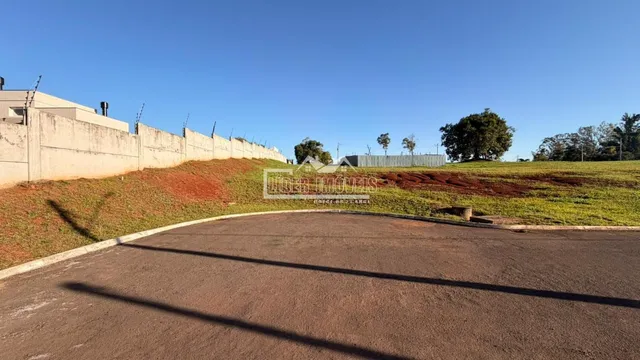 Vista da propriedade com muro e terreno gramado.
