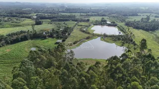 Vista aérea de uma propriedade com campos verdes e corpos d'água.