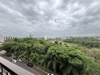 Vista panorâmica de uma área arborizada com uma estrada no primeiro plano.