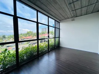 Sala de estar com grandes janelas que oferecem uma vista externa.