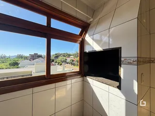 Parede interna com grande janela de vista para a paisagem externa e uma lareira.