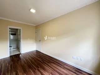 Sala de estar com piso de madeira e paredes claras.