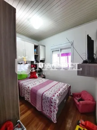 Foto de um quarto com cama e armários brancos em um imóvel.
