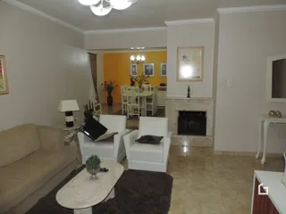 Uma sala de estar clara com sofá e lareira em um imóvel.