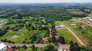 Vista aérea de uma área rural com vegetação densa e estradas de terra.
