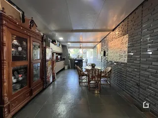 Interior de uma sala de jantar com paredes de tijolo e móveis de madeira.
