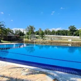Foto de uma piscina azul em uma área externa de uma propriedade.