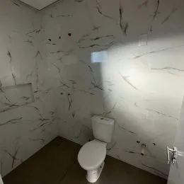 Foto de um banheiro com paredes revestidas em mármore branco.