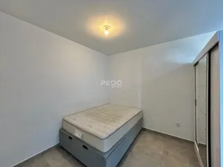 Quarto com cama e paredes brancas em um imóvel no Brasil.