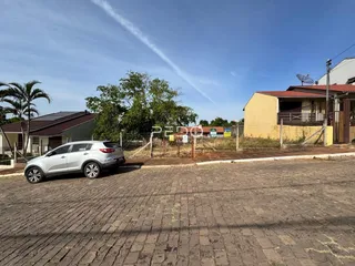 Vista externa de uma residência em Lajeado, Brasil, com uma rua pavimentada e um veículo estacionado.