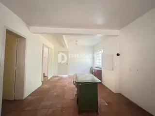 Corredor interno de uma residência com piso de cerâmica e paredes brancas.