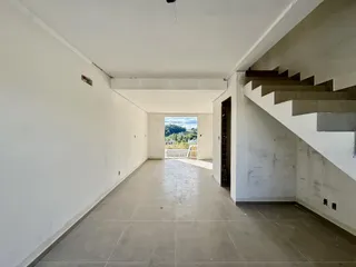 Hall de entrada longo com piso de porcelanato e escadaria lateral.
