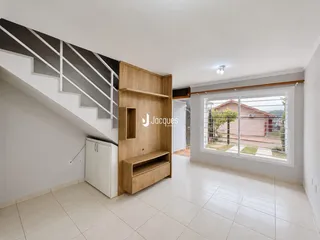 Interior de uma sala com piso de cerâmica e estante de madeira.