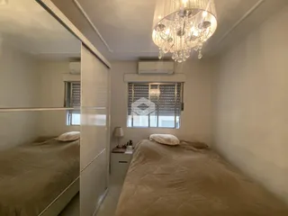 Quarto com cama de casal e janela em um imóvel no Brasil.