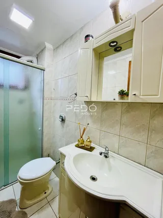 Foto de um banheiro com revestimento de azulejos brancos.